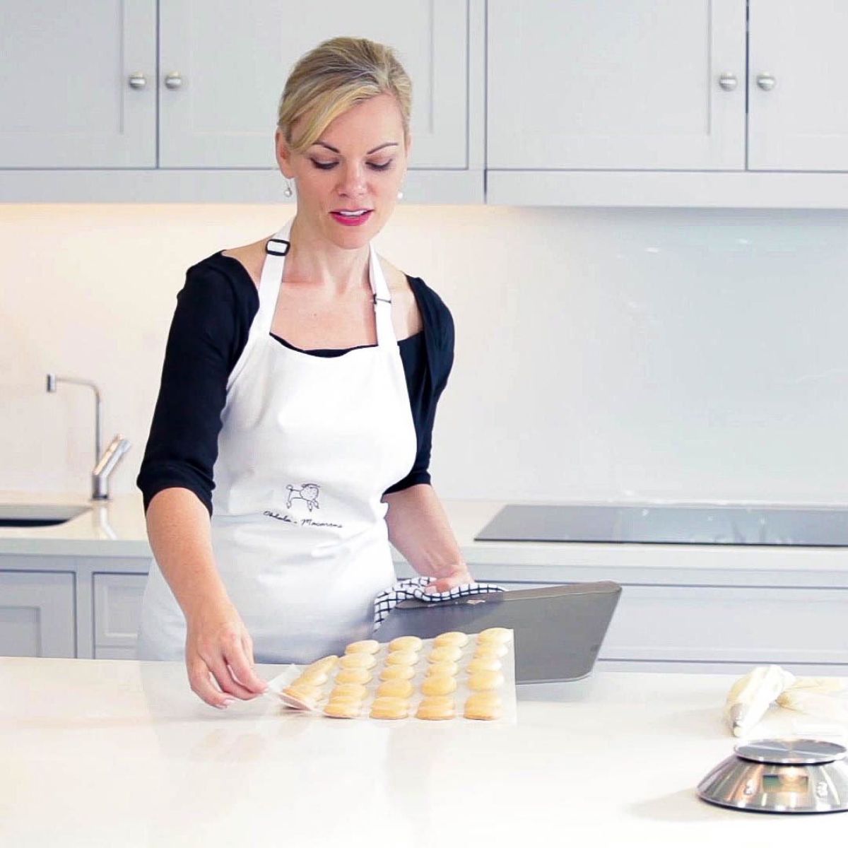 A woman baking macarons in the kitchen at Oh La La! Macarons