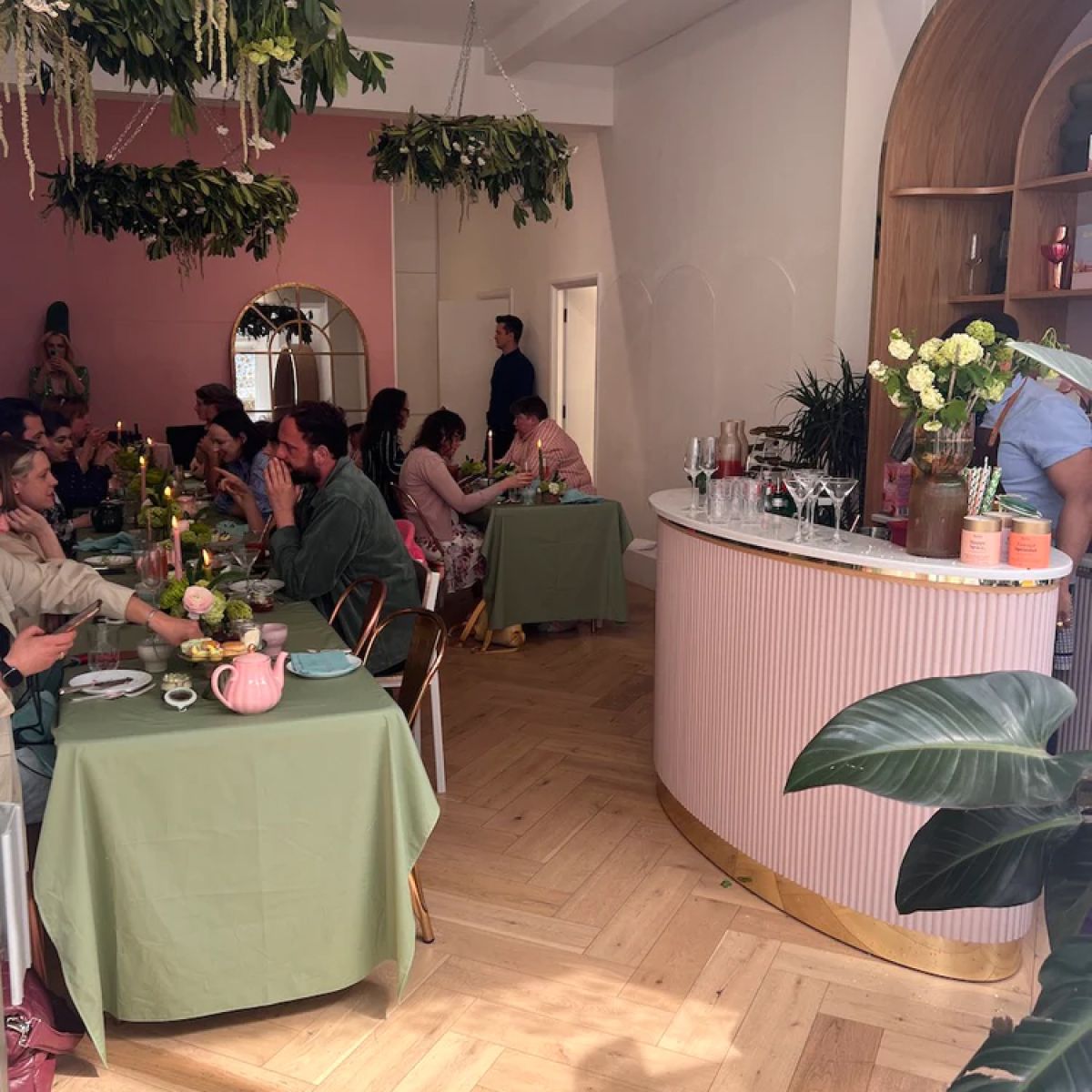 A large group of people enjoying an Oh La La! Macarons event featuring a cocktail bar