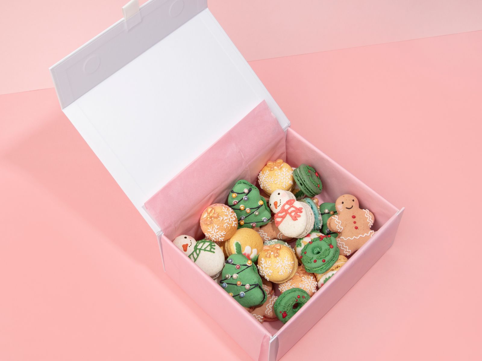 A pink box with an assortment of Oh La La! Christmas Macarons