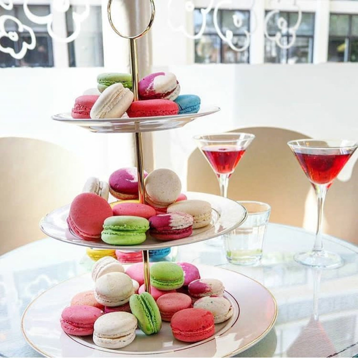 A three-tiered plate of multi-colored macarons accompanied by martinis at a hen party at Oh La La! Macarons