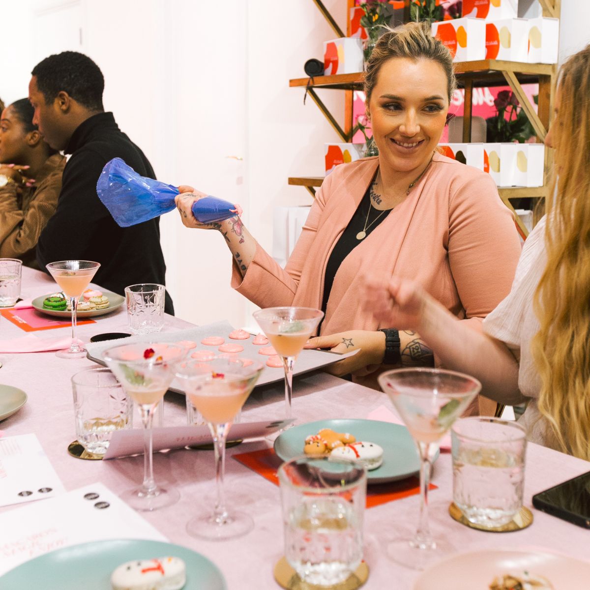 A table filled with people decorating macarons at a hen party at Oh La La! Macarons
